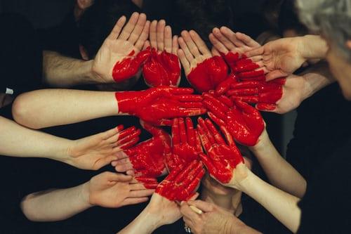 set of joined hands forming a painted heart between them.